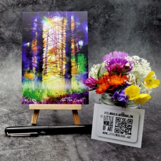 Image titled Into The Light, showing an A6 size greetings card, blank inside, on a small easel depicting a colourfully lit woodland scene.