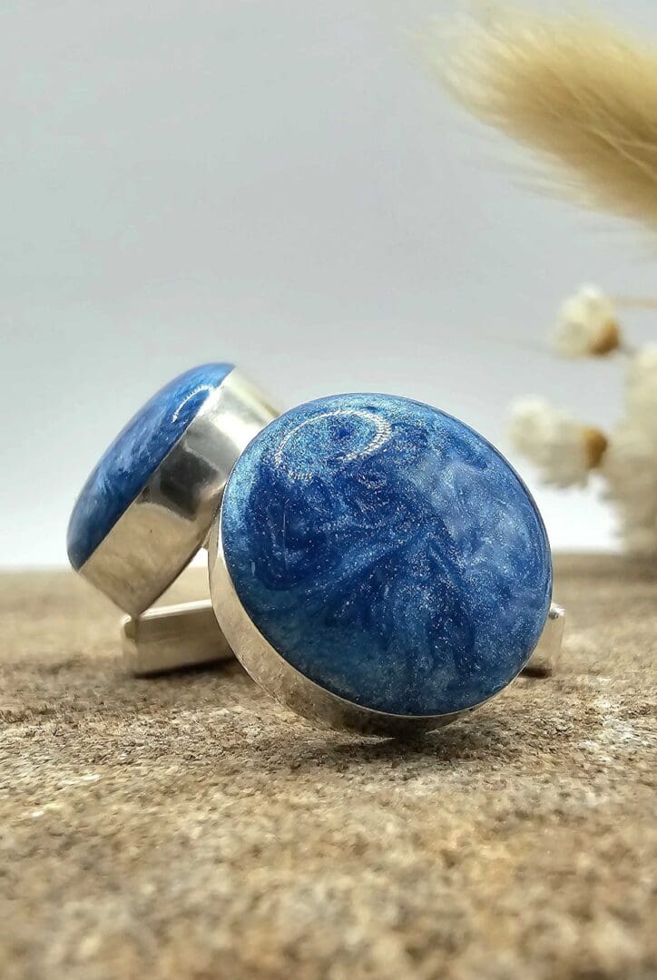 Close-up display of handmade sterling silver gents cufflinks with deep blue nebula-like resin keepsake stone on each cufflink