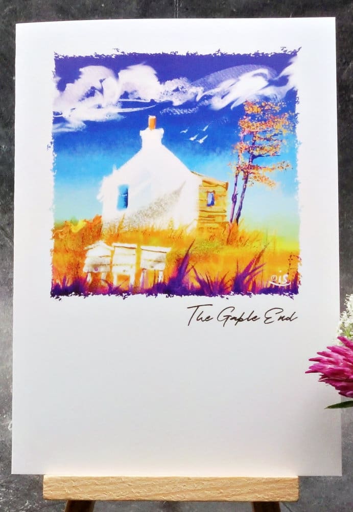 Larger image titled The Gable End showing an A6 size greetings card, blank inside, on a small easel depicting a view of a croft house gable end on a breezy sunny blue sky day.