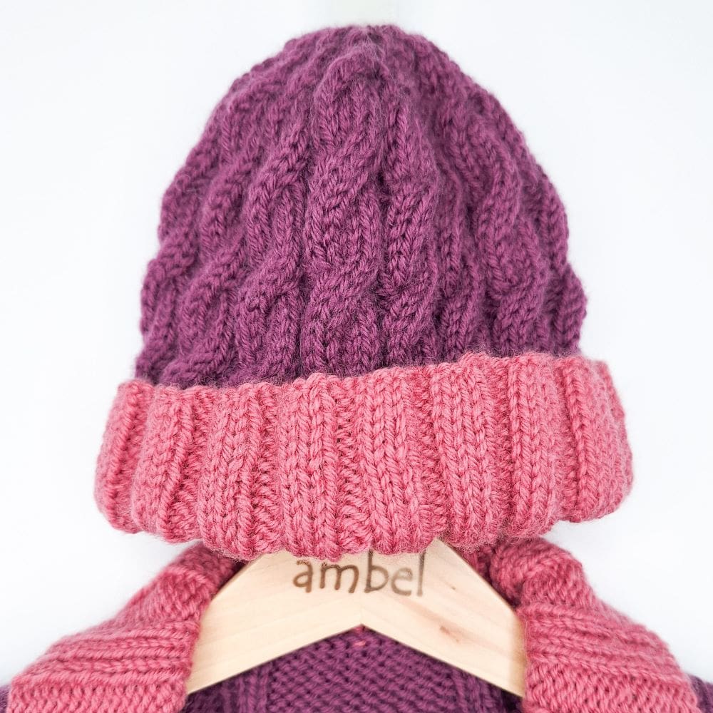 A cable knit beanie with matching cardigan on an ambel crafts wooden coathanger