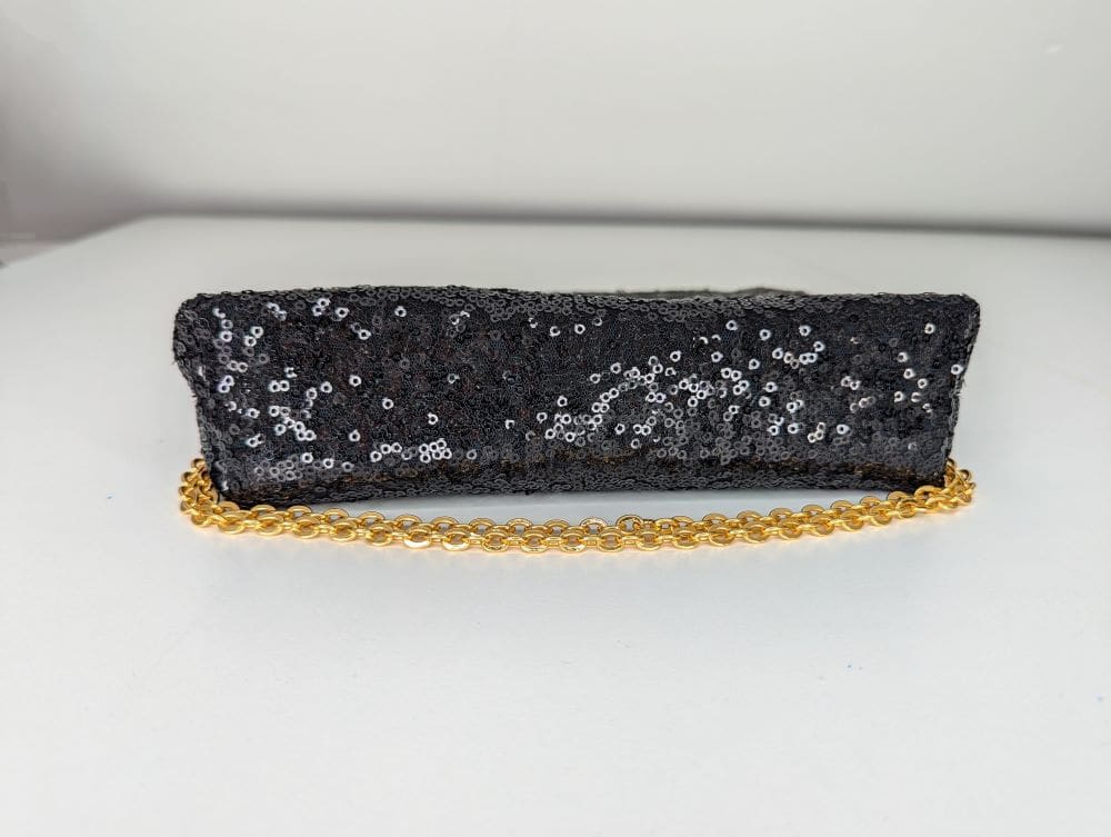 Black sequin shoulder bag with gold coloured chain shown