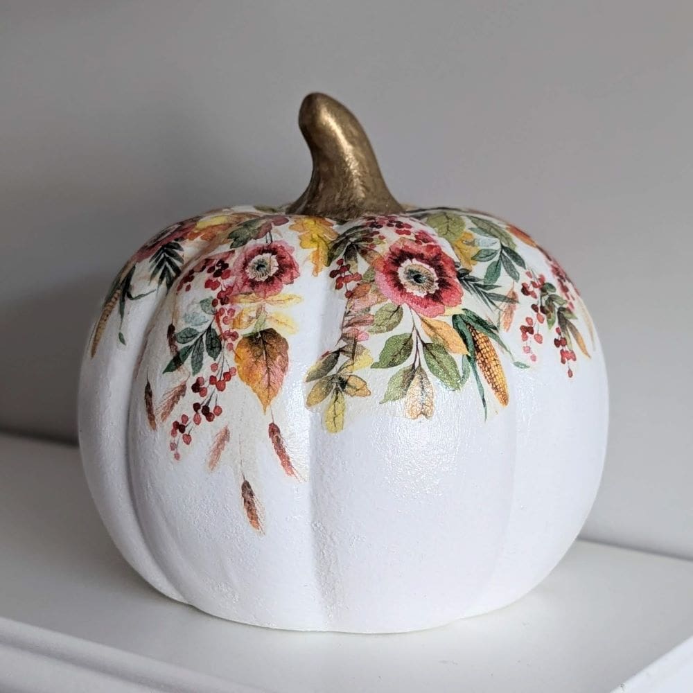 White ceramic 16.5cm pumpkin decoupaged with an Autumn leaves design and finished with a gold leaf stalk.