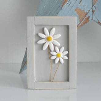 Miniature handmade wooden open frame in a distressed grey with two small clay white daisy flowers