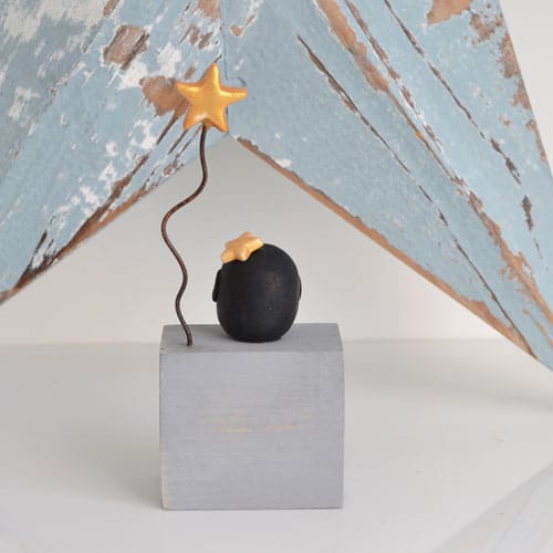 Handmade Merry Christmas decoration with grey wood base and clay penguin with gold star on wire.