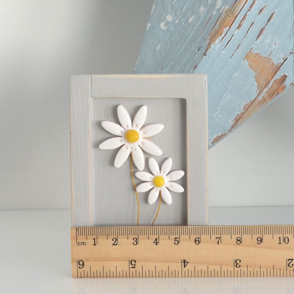 Miniature handmade wooden open frame in a distressed grey with two small clay white daisy flowers