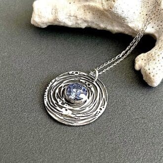 Round fine silver pendant with a 10mm. blue cubic zirconia stone displayed on a dark grey background