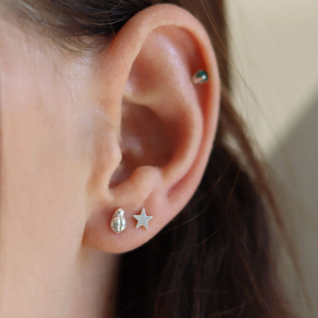 Close up of ear and silver ladybird earring