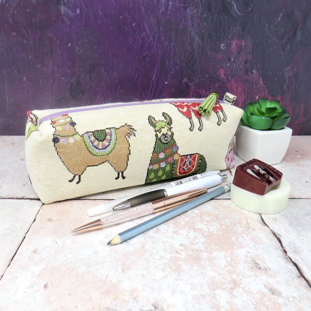 A large, boxy, Llama pencil case with a faux suede zip pull.