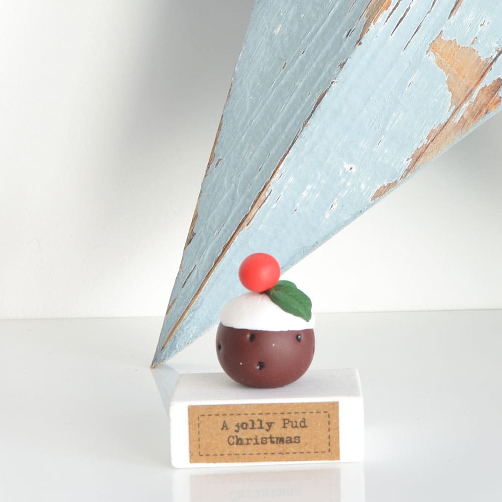 Clay Christmas Pudding ornament set on a white wooden base with the pun 'A Jolly Pud Christmas.