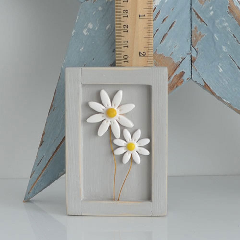 Miniature handmade wooden open frame in a distressed grey with two small clay white daisy flowers