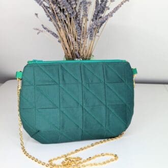 Green, quilted clutch bag with a gold coloured chain