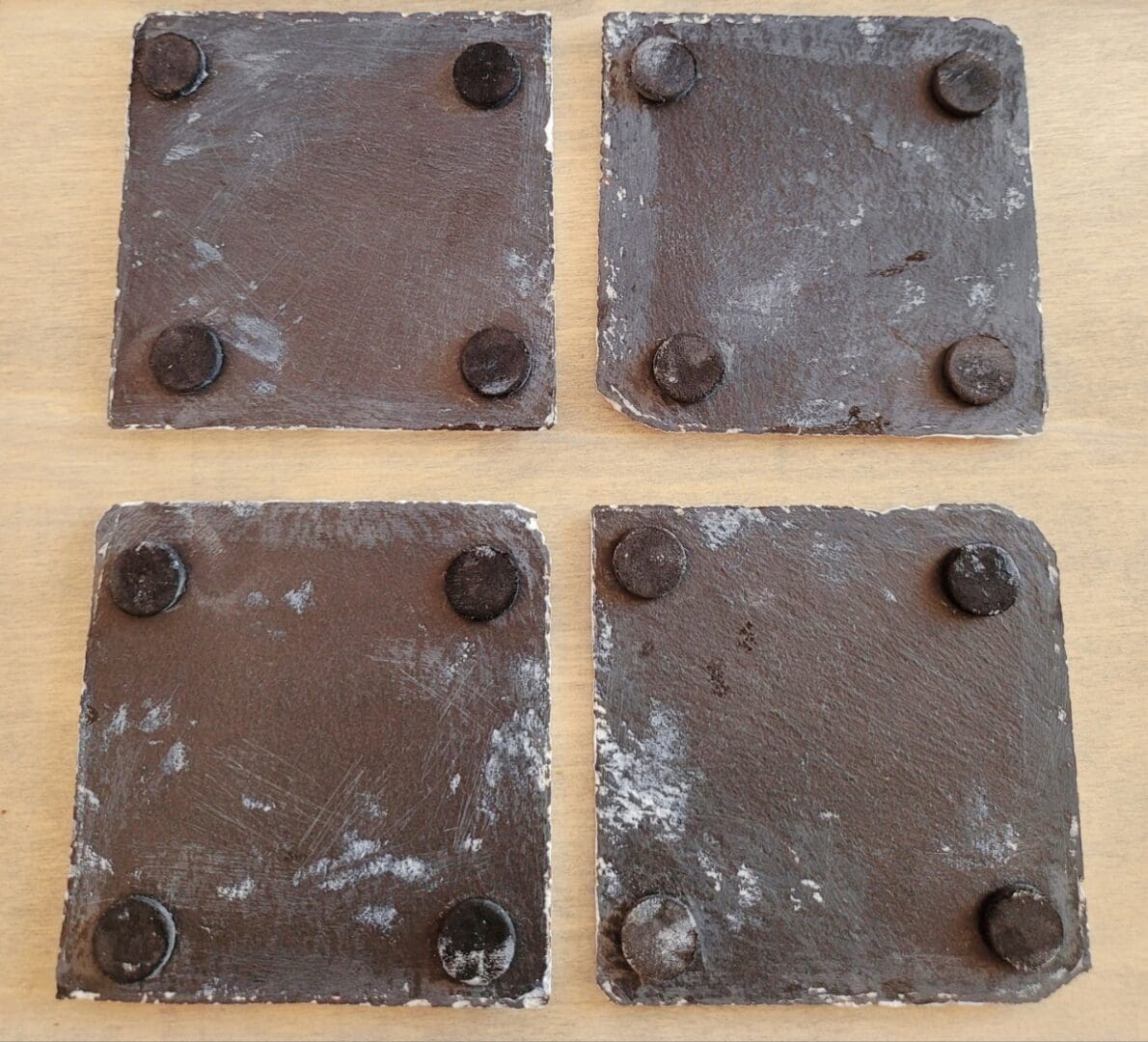 Four slate coasters with protective pads on the undersides