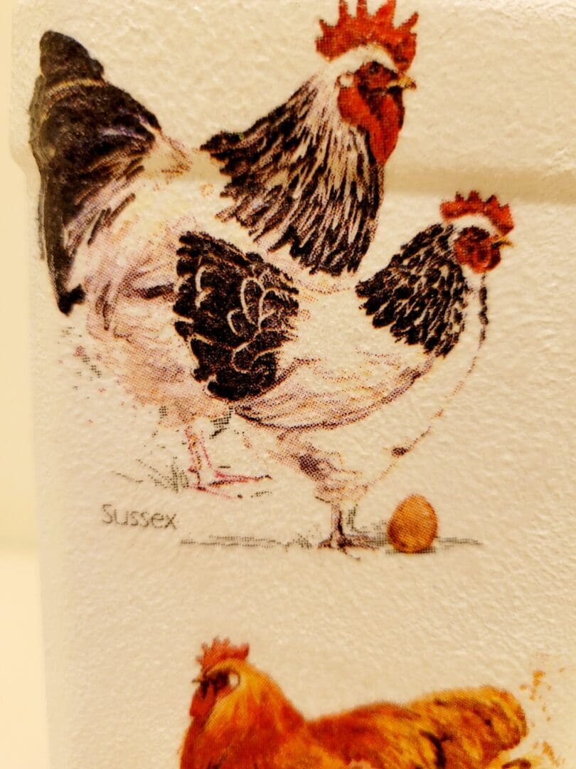 two chickens on the side of a white painted bottle