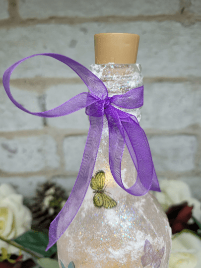 purple ribbon tied around the neck of a wine bottle