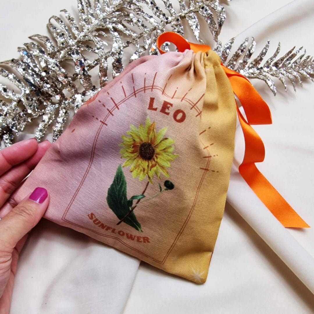 photo of a handmade cotton pouch with a digital print of the leo start sign and its birth flower, the sunflower