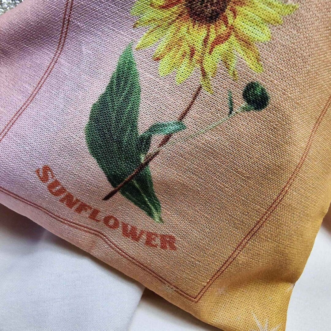 photo of a handmade cotton pouch with a digital print of the leo start sign and its birth flower, the sunflower