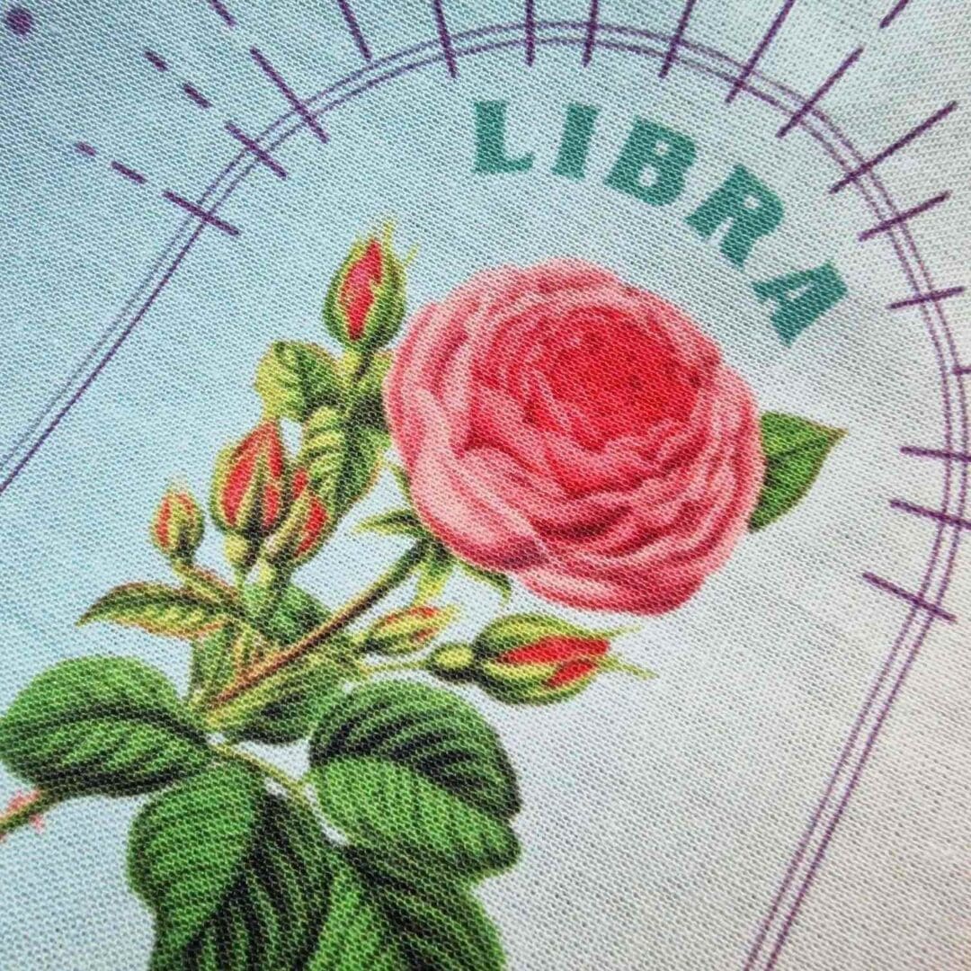 photo of a handmade cotton pouch with digital print of the libra birth flower, rose. finished with an eco-satin ribbon tie