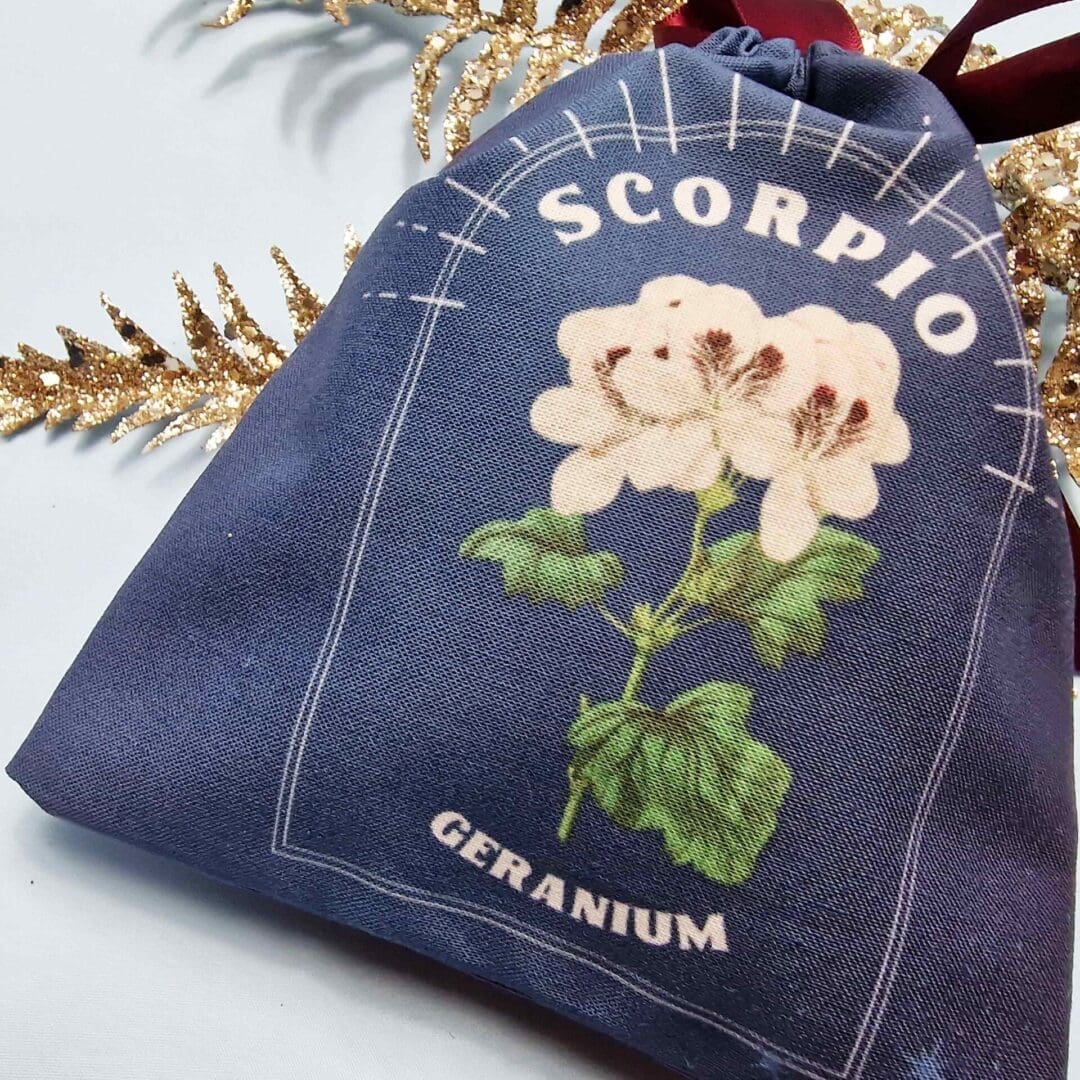 photo of a handmade cotton pouch featuring a digitial print of scorpio's birth flower, the geranium