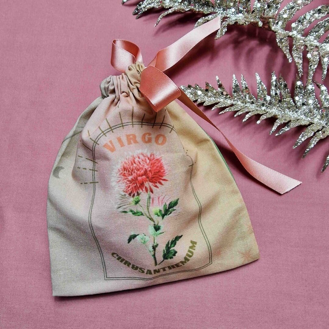 photo of a handmade cotton pouch with digital print of virgo birth flower, carnation.