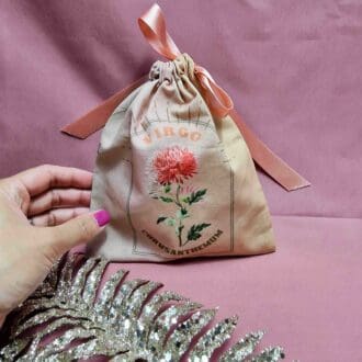 photo of a handmade cotton pouch with digital print of virgo birth flower, carnation.