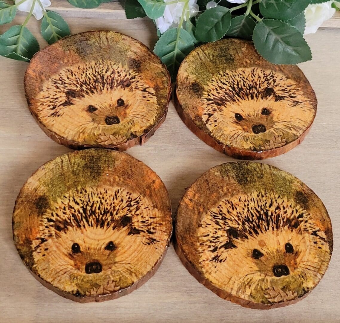 set of four round wood slice coasters, each with a hedgehog image