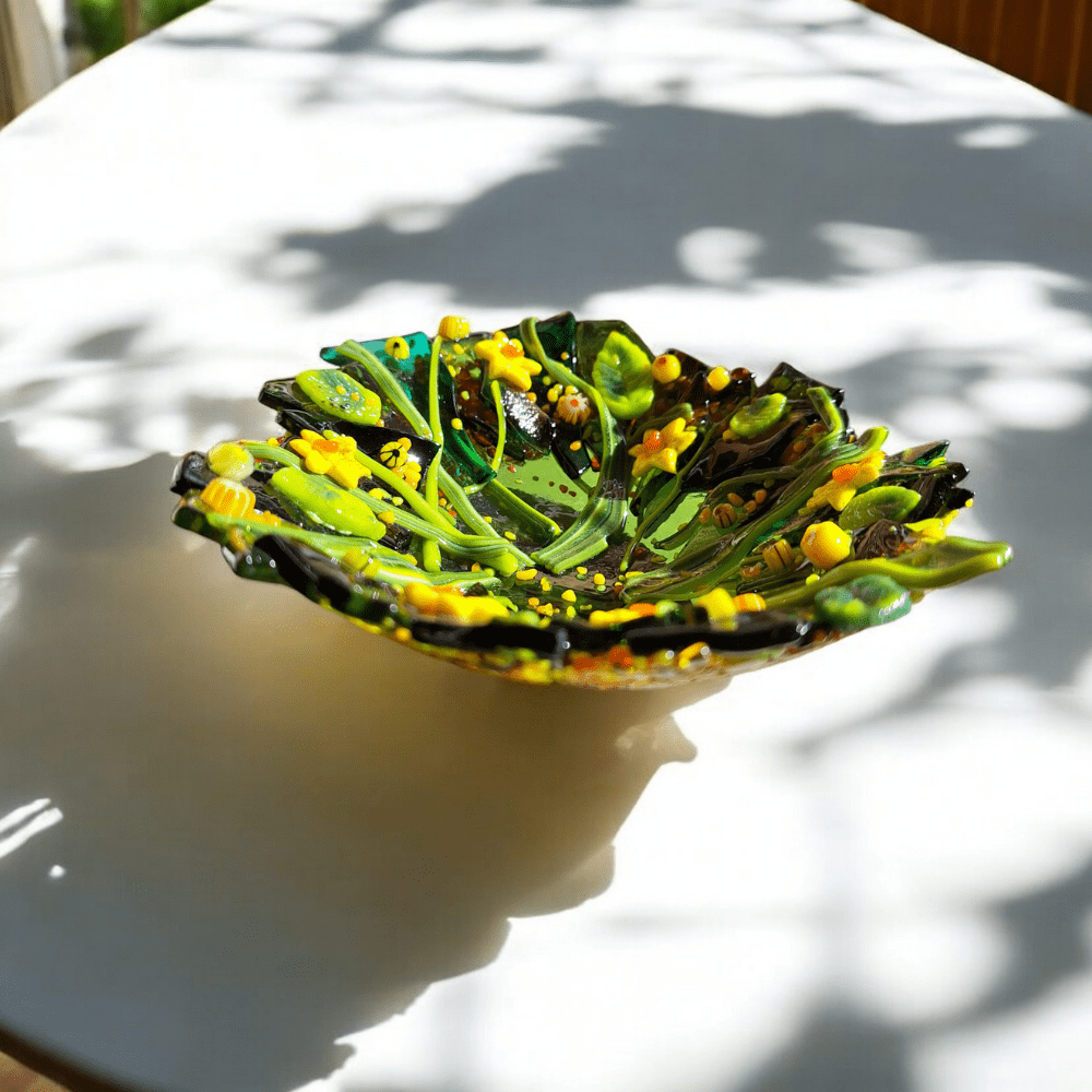 Handmade fused glass daffodil bowl with vibrant yellow flowers and green leaves, perfect for a housewarming gift or botanical home decor. 14 cm diameter and 4.5 cm height, crafted in a home studio with unique nature-inspired design. Ideal as a decorative dish or earring holder