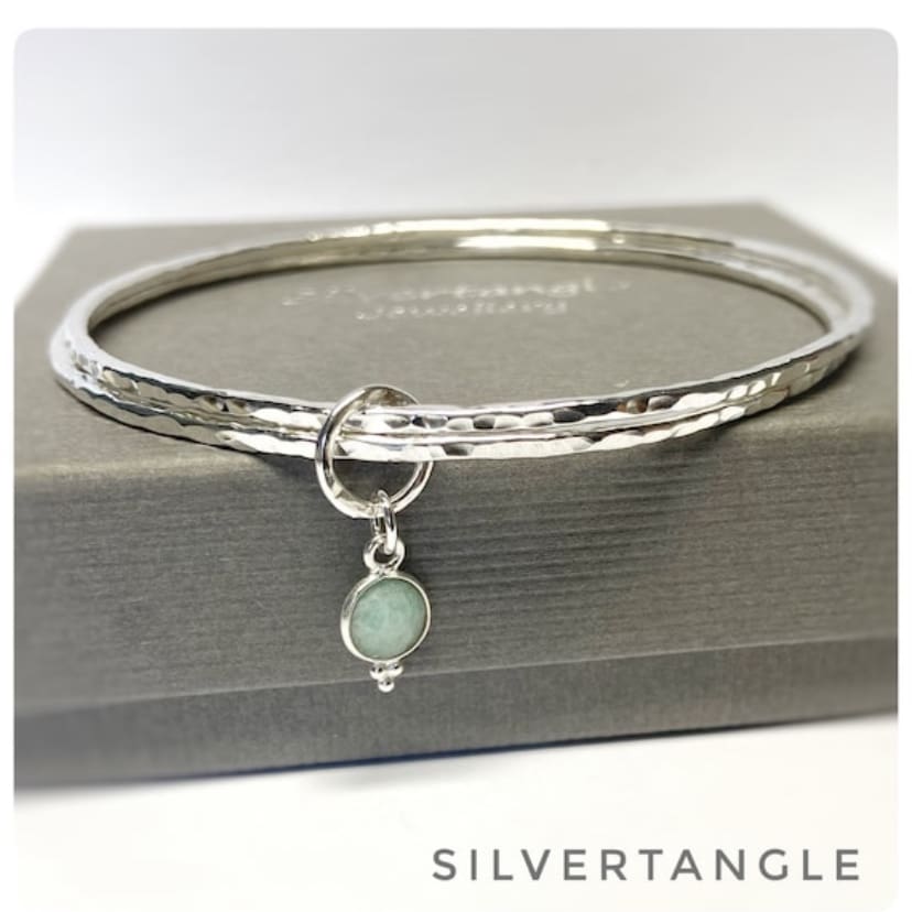 Two Hammered silver bangles joined with an Amazonite faceted charm.