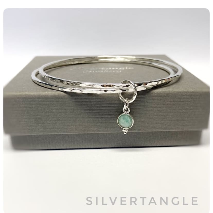 Two Hammered silver bangles joined with an Amazonite faceted charm.