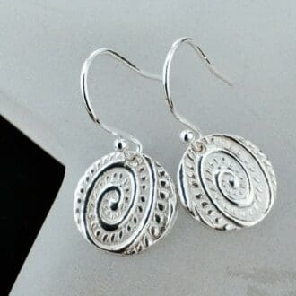 A pair of drop earring with a textured design in the Art Nouveau style much like a fiddlehead fern