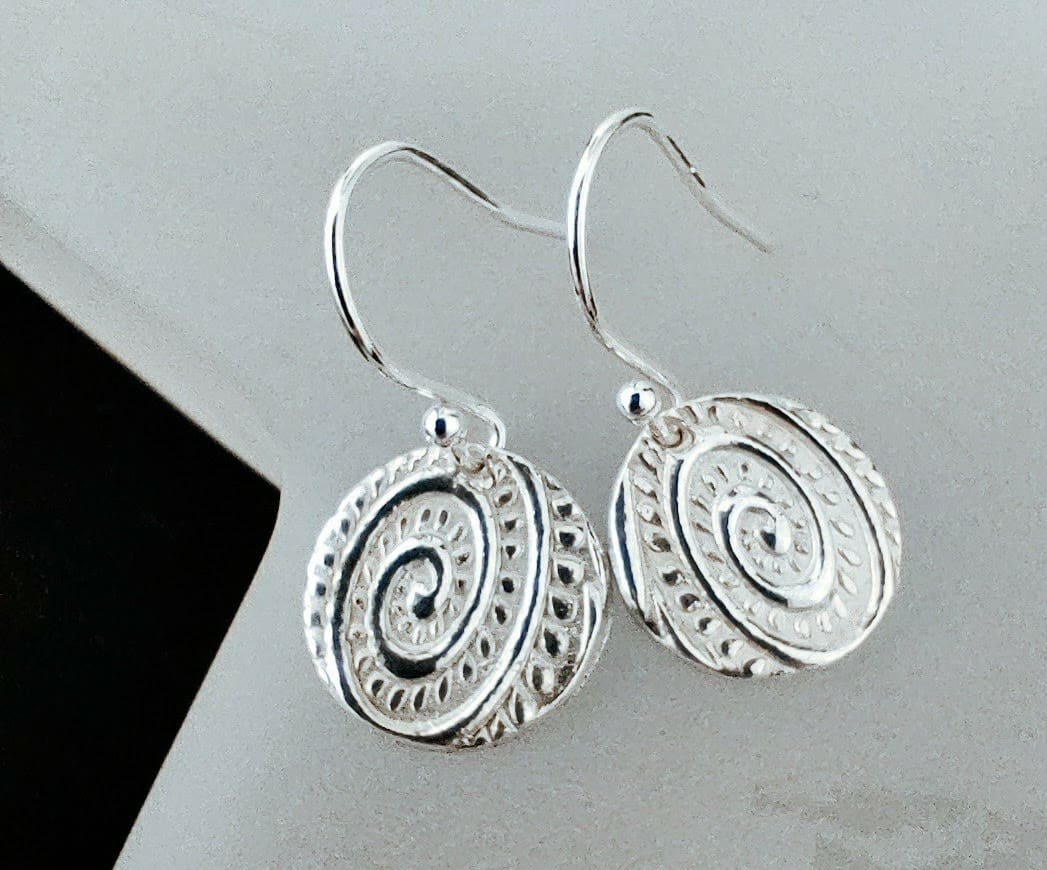 A pair of drop earring with a textured design in the Art Nouveau style much like a fiddlehead fern