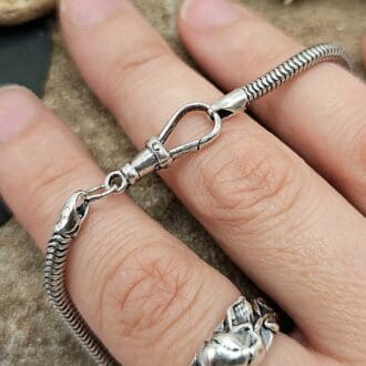 Handmade recycled sterling silver snake charm universal bead bracelet with albert clasp displayed across jeweller's fingers