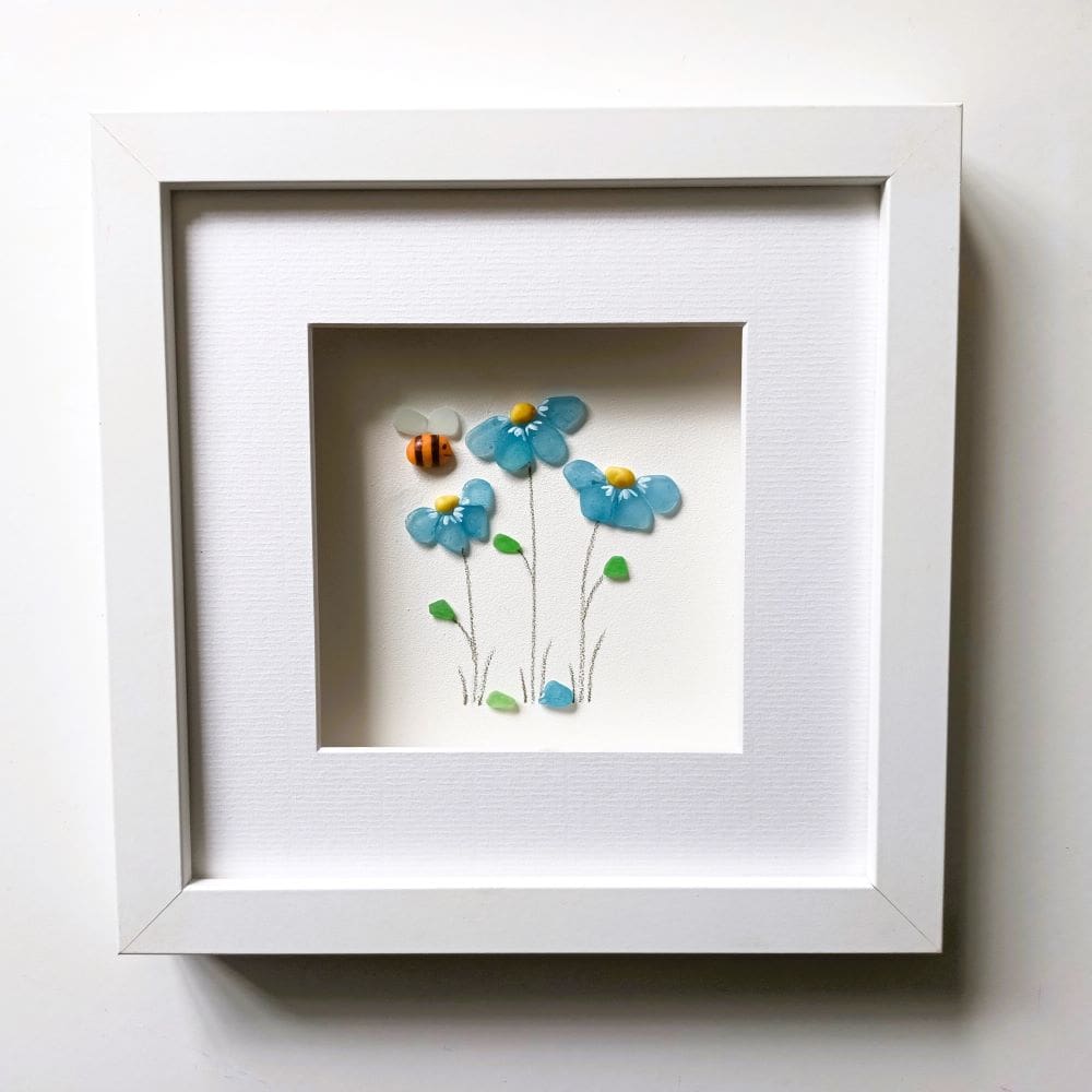 framed picture of forget me not flowers made with tiny nuggets of cornish sea glass