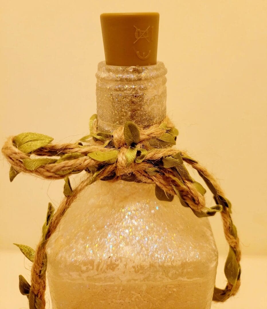 Leafy jute twine tied around the neck of a bottle. Brown plastic cork