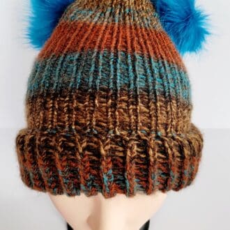 Brown and blue striped hat with brim featuring two blue fluffy pom poms