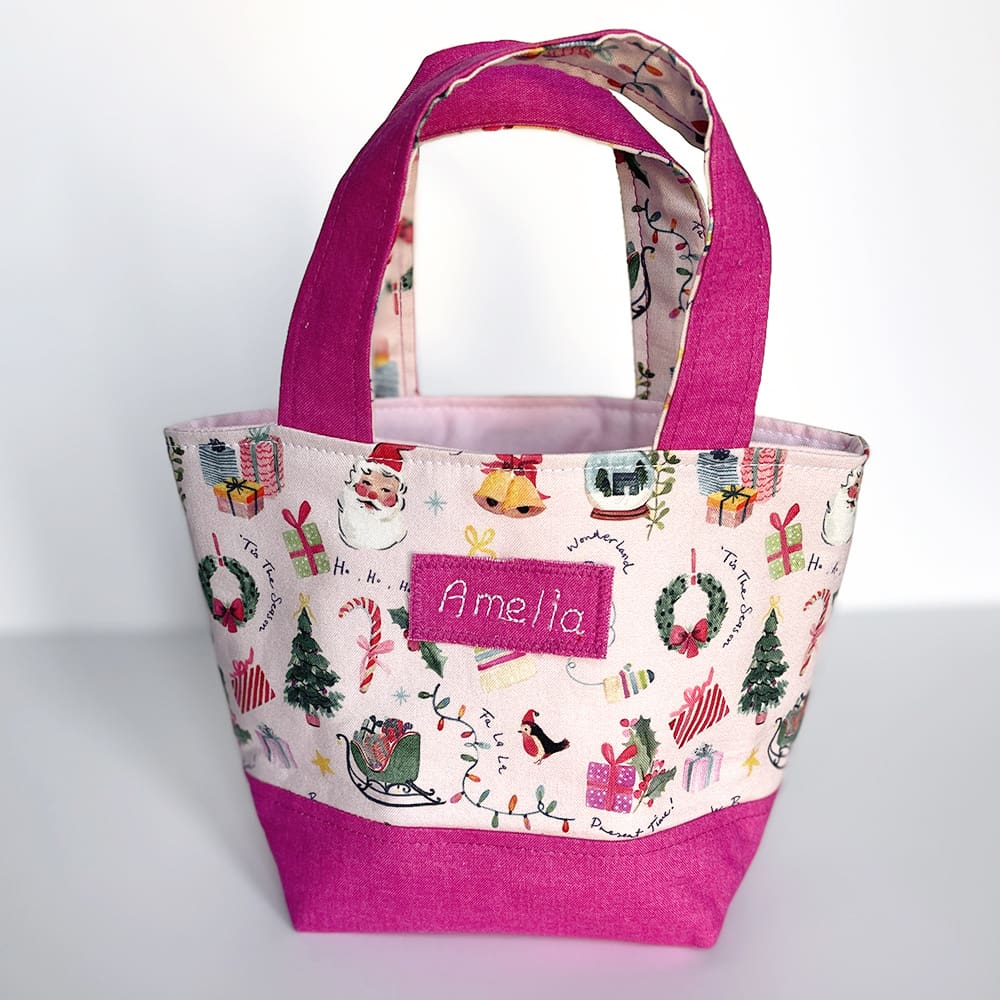 Toy Christmas shopping bag in pink fabric with child's name.