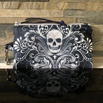 A coin and card purse, in blue with Halloween skulls. Integral lobster clasp for attaching to keys or lanyard