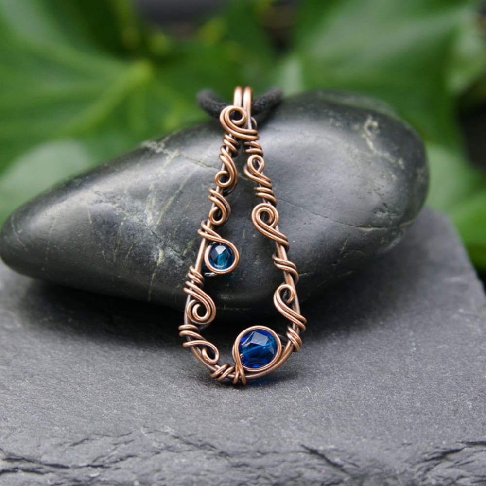 Simple copper wire wrapped teardrop pendant with blue glass beads by Oruki Design