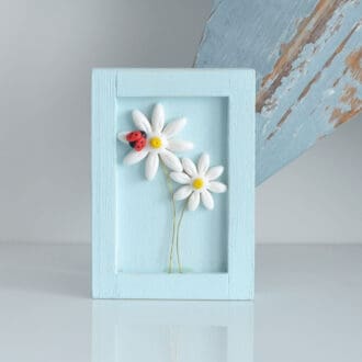 Handmade small wooden frame in duck egg blue with two daisy flowers and tiny ladybird.