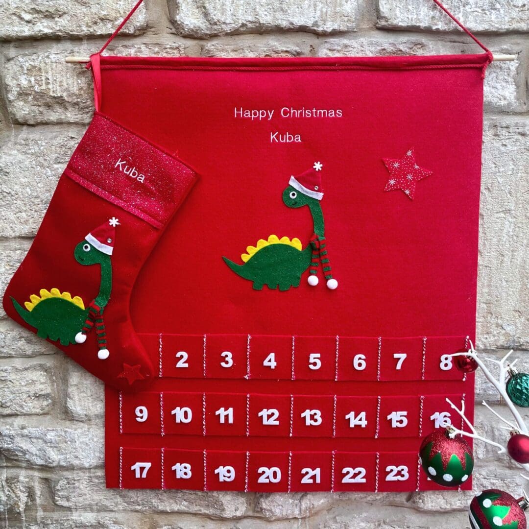 Personalised Christmas advent and matching stocking featuring a dinosaur dressed in a hat a scarf to keep himself warm