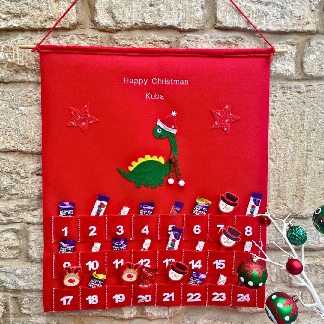 Personalised Christmas advent and matching stocking featuring a dinosaur dressed in a hat a scarf to keep himself warm