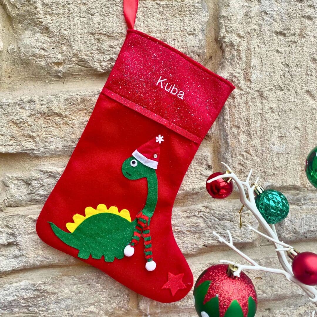 Personalised Christmas advent and matching stocking featuring a dinosaur dressed in a hat a scarf to keep himself warm