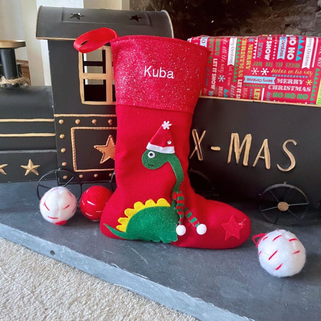 Personalised Christmas advent and matching stocking featuring a dinosaur dressed in a hat a scarf to keep himself warm