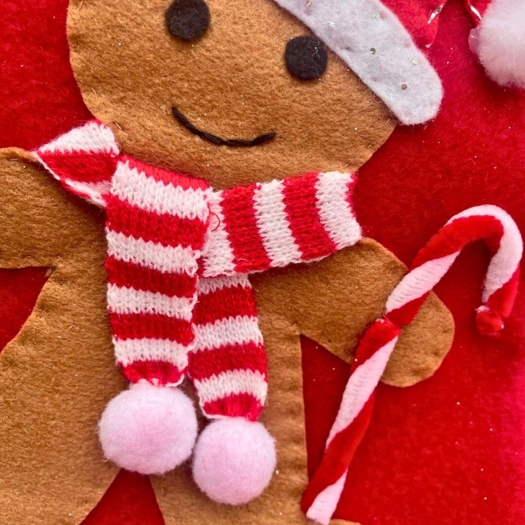 Christmas stocking featuring a gingerbread boy wearing a hat and scarf to keep warm