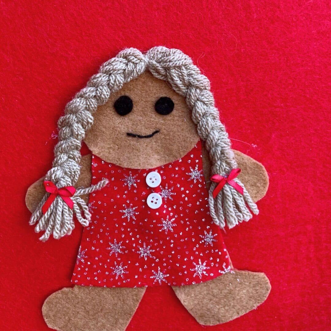 Christmas stocking featuring a gingerbread girl with a red sparkly dress and hair in pigtails