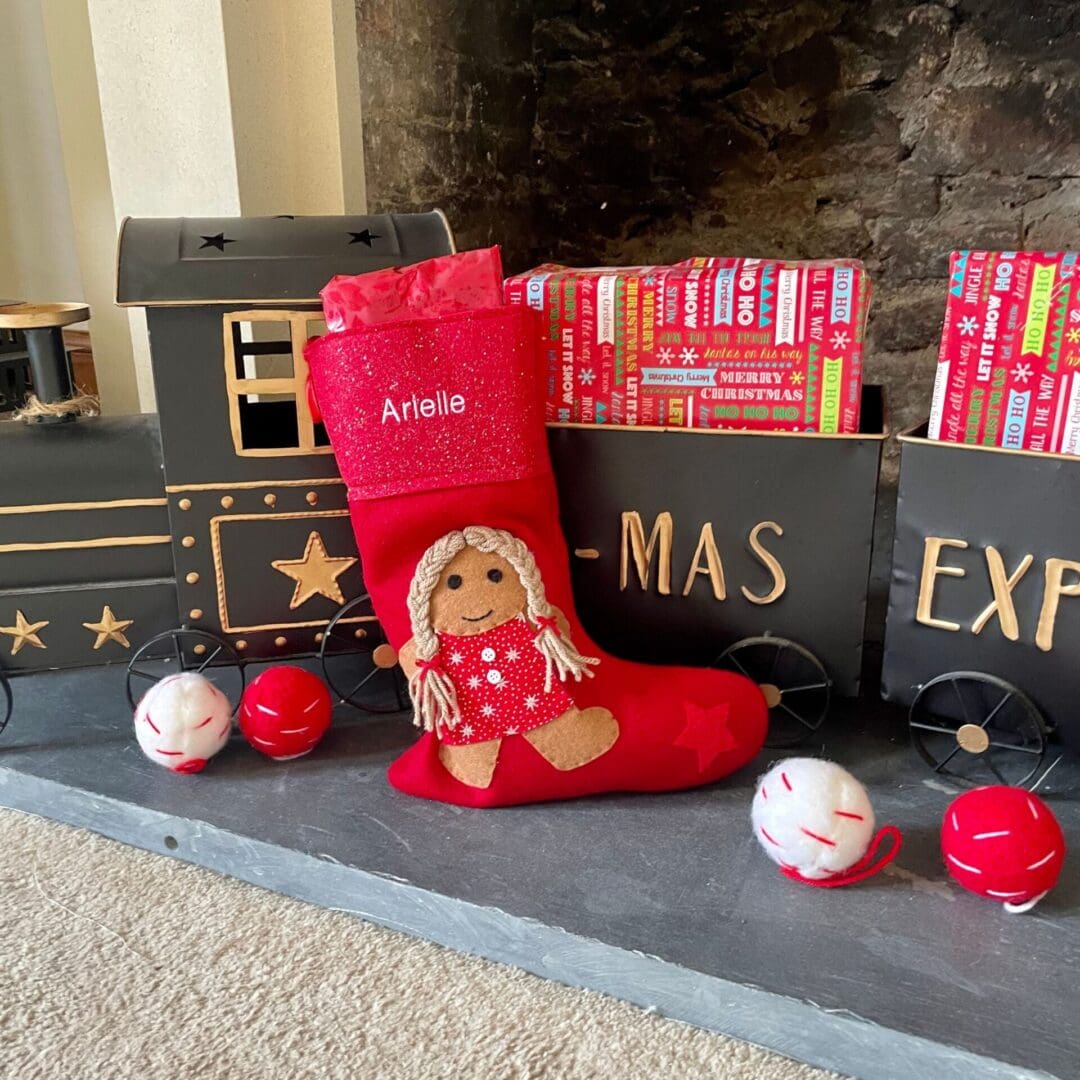 Christmas stocking featuring a gingerbread girl with a red sparkly dress and hair in pigtails