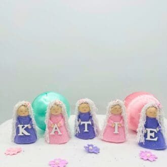 Pink and purple glitter dolly pegs holding a letter