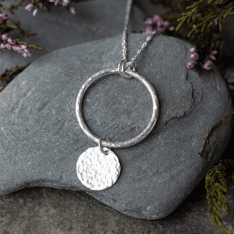 sterling silver necklace featuring an open circle with disc charm