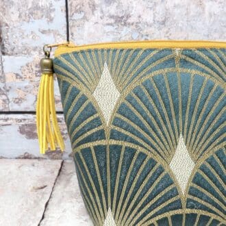 Teal green and gold art deco makeup bag with a faux suede tassel zip pull