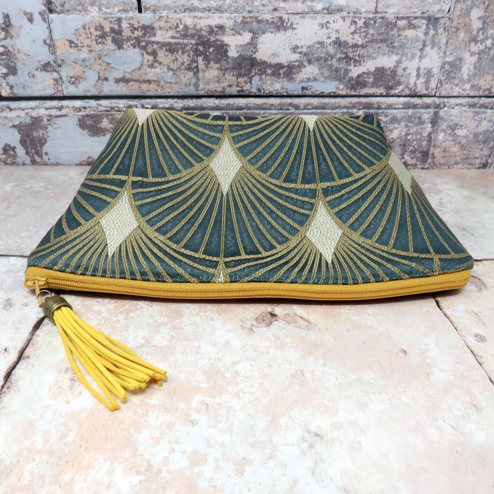 Teal green and gold art deco makeup bag with a faux suede tassel zip pull