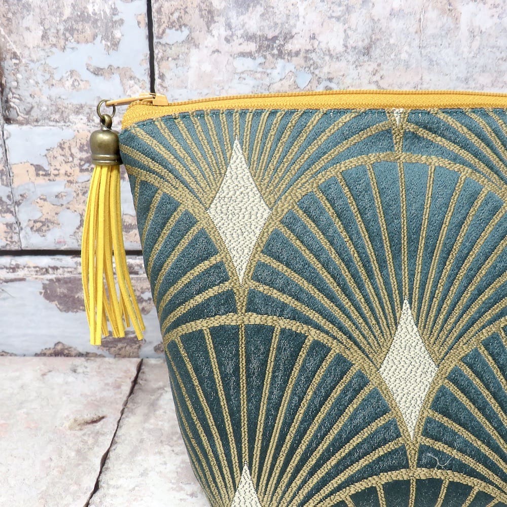 Teal green and gold art deco makeup bag with a faux suede tassel zip pull